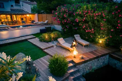 a woman standing on a wooden deck in a backyard at Villa Sempietru, 8 pers, lagon & plage à pied in Lecci