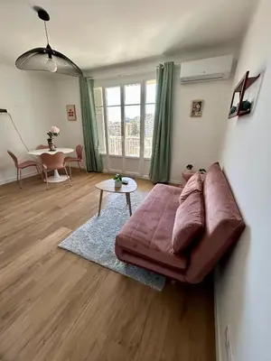 a living room with a purple couch and a table at Le Romane- appartement T2 proche centre-ville et parking gratuit in Ajaccio