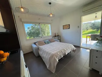 a bedroom with a bed and a large window at Maison à 2 minutes de la mer en voiture in Sorbo-Ocagnano