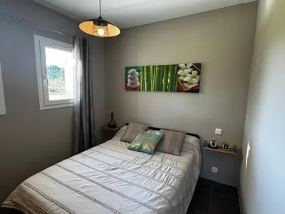 a bedroom with a bed and a picture on the wall at Maison à 2 minutes de la mer en voiture in Sorbo-Ocagnano