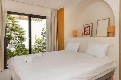 a bedroom with a large white bed with a window at Balamb Garden A Rinascita in Ajaccio