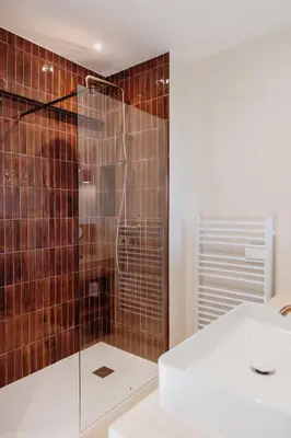 a bathroom with a shower with brown tiles at Balamb Garden A Rinascita in Ajaccio