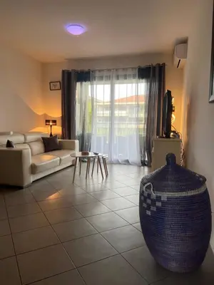 a living room with a couch and a vase on the floor at CORSE RESIDENCE COSTA D'ORO Folelli F2 in Penta-di-Casinca