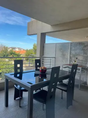 a dining room with a table and chairs on a balcony at CORSE RESIDENCE COSTA D'ORO Folelli F2 in Penta-di-Casinca