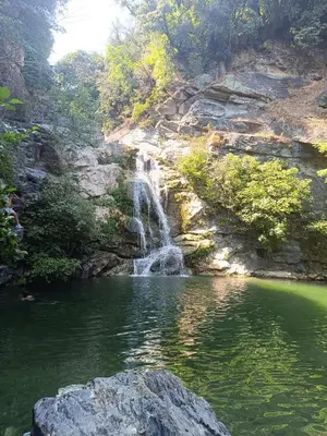 a waterfall in front of a pool of water at CORSE RESIDENCE COSTA D'ORO Folelli F2 in Penta-di-Casinca