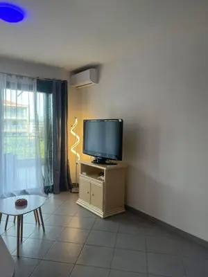 a living room with a flat screen tv on a stand at CORSE RESIDENCE COSTA D'ORO Folelli F2 in Penta-di-Casinca