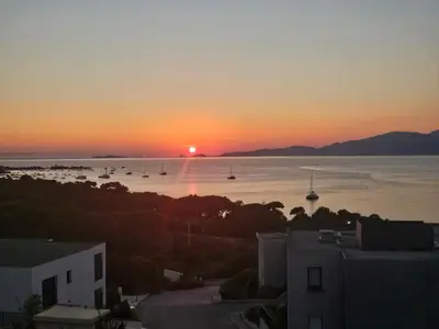 a sunset over a body of water with boats at 1vue,1 lieu, Des vacances in Pietrosella