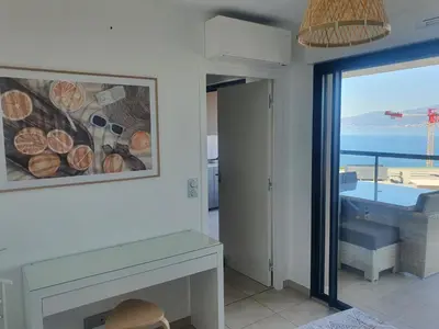 a living room with a fireplace and a view of the ocean at 1vue,1 lieu, Des vacances in Pietrosella