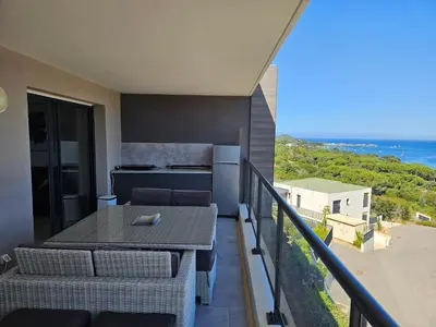 a balcony with a table and a view of the ocean at 1vue,1 lieu, Des vacances in Pietrosella