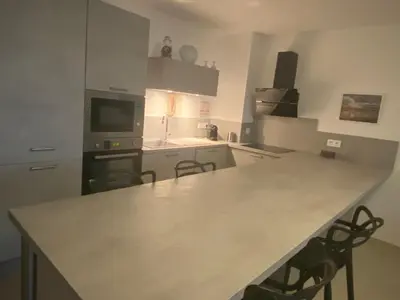 a kitchen with a counter top and chairs in it at Pietrosella Bord de Mer in Pietrosella