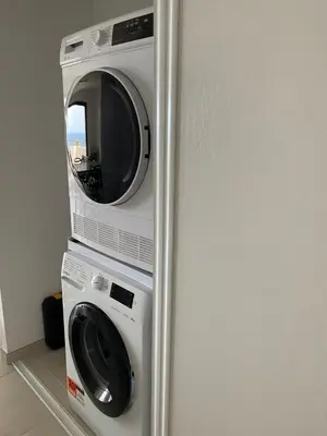 a refrigerator with a microwave and a washing machine at Pietrosella Bord de Mer in Pietrosella