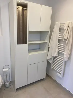 a white closet with white cabinets and towels at Pietrosella Bord de Mer in Pietrosella