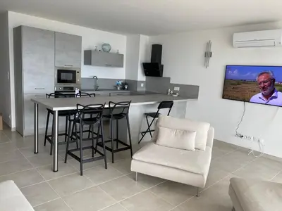 a kitchen with a table and chairs in a room at Pietrosella Bord de Mer in Pietrosella