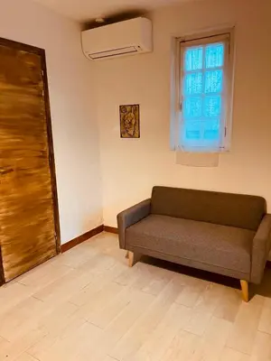 a living room with a couch and a window at La parenthèse in Lucciana