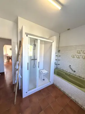 a bathroom with a glass shower and a tub at Chez nous in Lucciana