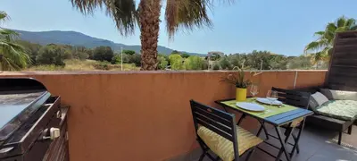 a table and chairs on a balcony with a grill at T2 Port de Porto Vecchio 4 pers vue Montagne in Porto-Vecchio