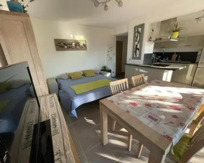 a bedroom with a bed and a table and a kitchen at T2 Port de Porto Vecchio 4 pers vue Montagne in Porto-Vecchio
