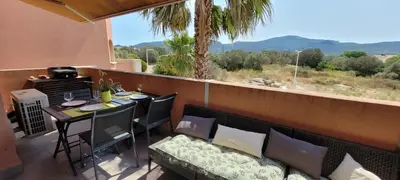 a balcony with a couch and a table with a view at T2 Port de Porto Vecchio 4 pers vue Montagne in Porto-Vecchio