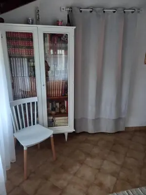 a white cabinet and a chair in a room at Appartement Casa Rose in Sollacaro