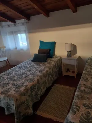 a bedroom with a bed with blue pillows on it at Appartement Casa Rose in Sollacaro