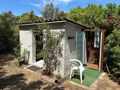 a small shed with a chair in front of it at Mobil-Home U Forconu in Pianottoli-Caldarello