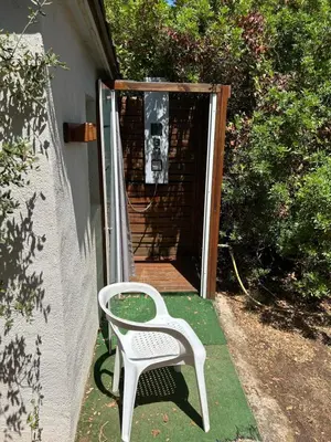 a white chair sitting on the porch of a house at Mobil-Home U Forconu in Pianottoli-Caldarello