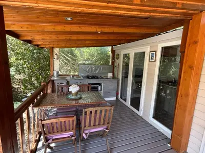 a patio with a table and chairs on a deck at Mobil-Home U Forconu in Pianottoli-Caldarello