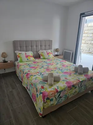 a bedroom with a large bed with shoes on it at Chez Corinne et Paul classé 3 Etoiles in Propriano