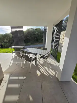 a patio with a table and chairs on a porch at Chez Corinne et Paul classé 3 Etoiles in Propriano