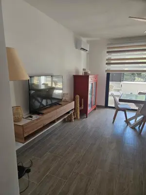 a living room with a large aquarium and a table and chairs at Chez Corinne et Paul classé 3 Etoiles in Propriano