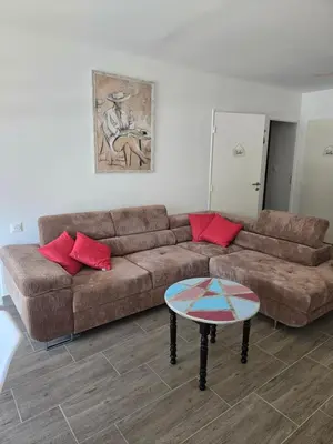 a living room with a brown couch and a table at Chez Corinne et Paul classé 3 Etoiles in Propriano