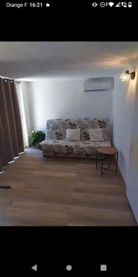 a bed in a white room with a table at Bas de villa à 100 M de la plage in Solaro