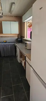 a kitchen with a washer and dryer in it at Bed and kitchen with pool in Aléria