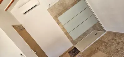 a glass shower door in a bathroom at Bed and kitchen with pool in Aléria