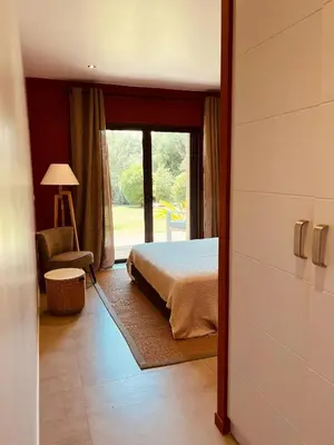 a bedroom with a bed and a chair and a window at Peaceful Villa Between Sea And Mountain In Corsica in Lecci