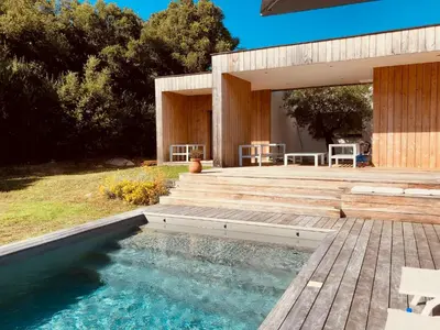 a house with a swimming pool and a wooden deck at Peaceful Villa Between Sea And Mountain In Corsica in Lecci