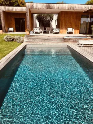 a swimming pool with blue water in front of a house at Peaceful Villa Between Sea And Mountain In Corsica in Lecci