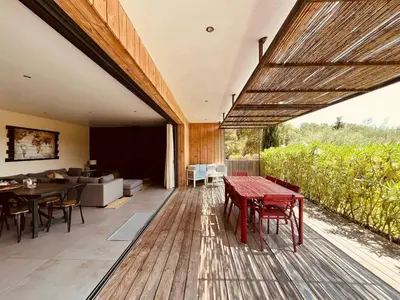 a deck with tables and chairs and a living room at Peaceful Villa Between Sea And Mountain In Corsica in Lecci