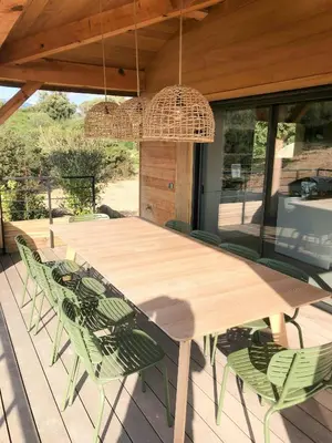 a kitchen and dining room with a cat laying on a chair at Modern Villa With Sea View In Corsica in Pianottoli-Caldarello