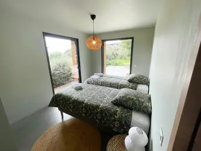 two beds in a bedroom with a large window at Modern Villa With Sea View In Corsica in Pianottoli-Caldarello