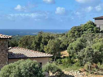 a wooden walkway with flowers on the side of a building at Modern Villa With Sea View In Corsica in Pianottoli-Caldarello