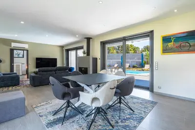 a living room with a table and chairs at La Villa Grazzoso - Piscine Privée in Sainte-Lucie de Porto-Vecchio