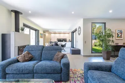 a living room with a blue couch and a fireplace at La Villa Grazzoso - Piscine Privée in Sainte-Lucie de Porto-Vecchio