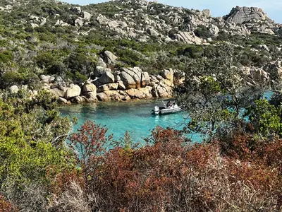 a boat in a river near a rocky mountain at Mini villa Corse du sud Residence U Re D Alzetu in Lecci