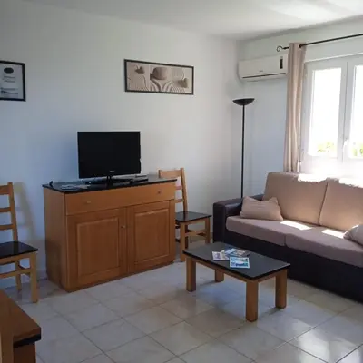 a living room with a couch and a flat screen tv at Villa A7 Aulyna - Vue mer climatisée in Cervione