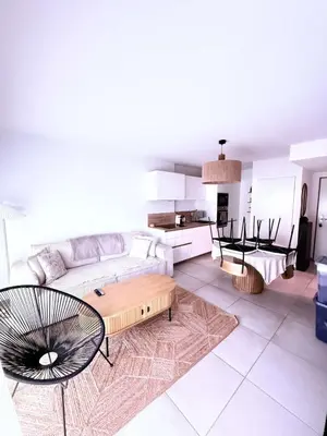 a living room with a couch and a table at Appartement neuf Porticcio in Porticcio
