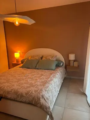 a bedroom with a bed and a orange wall at Appartement neuf Porticcio in Porticcio