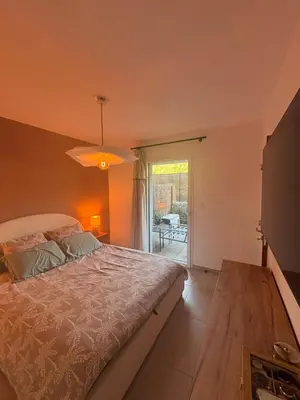 a bedroom with a bed and a sliding glass door at Appartement neuf Porticcio in Porticcio