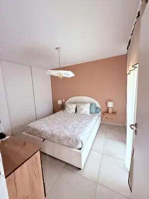 a white bedroom with a bed and a window at Appartement neuf Porticcio in Porticcio