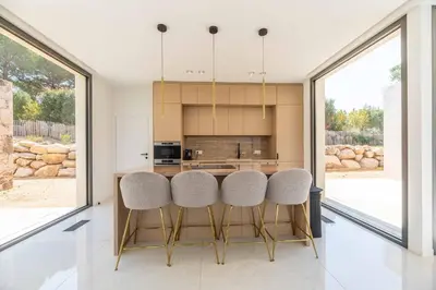 a kitchen with a table and some chairs at Villa Monte Sereno Pinarellu in Pinarellu